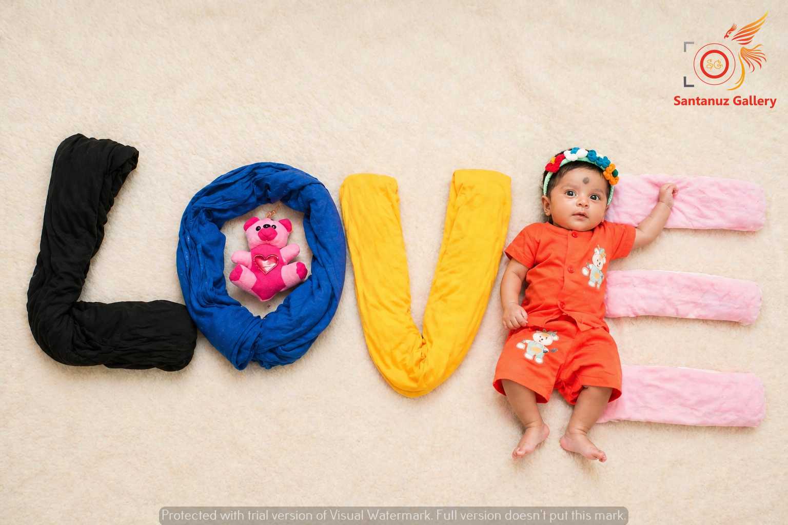 Newborn Photography Kolkata 18 Close-up of tiny, wrinkled pink newborn baby feet with delicate toes, held gently in a parent's larger hands, on a soft blue knitted blanket